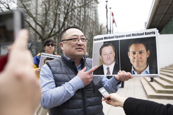 2019年3月6日，在温哥华卑诗省省最高法院外，黄先生手持两名被中国关押的加拿大人的照片。