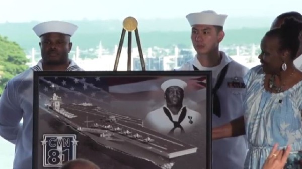 多里斯．米勒（Doris Miller）的家人聚集在肖像旁邊，以紀念珍珠港英雄和未來將以他的名字命名的航空母艦。 （圖片來源：美國國防部）