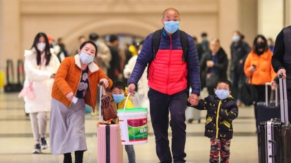 2020年1月21日戴着口罩的通勤者在武汉市的汉口火车站行走