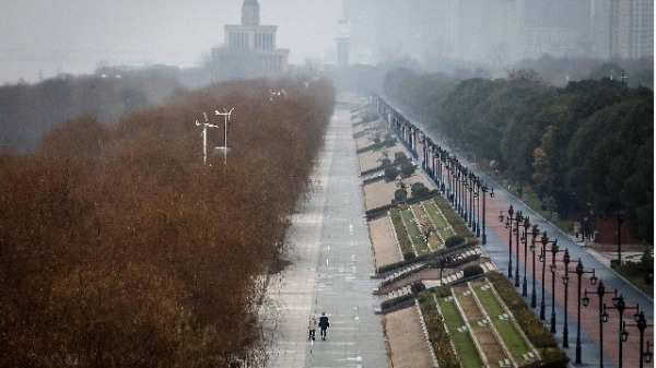 圖為武漢封城後，2名路人行走在冷冷清清的大街上