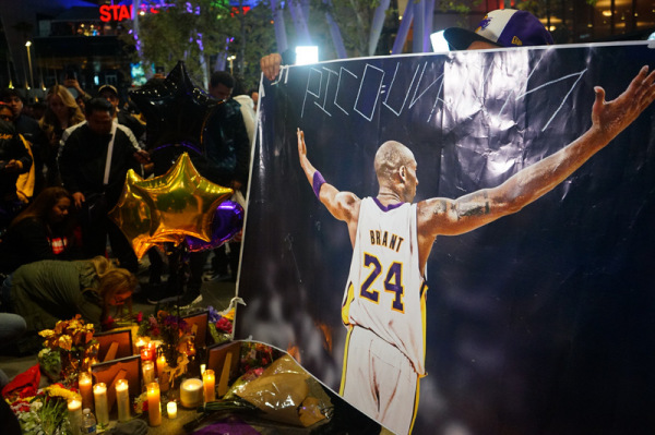 美国职篮NBA洛杉矶湖人传奇球星布莱恩（Kobe Bryant ）26日不幸坠机过世，大批球迷聚集在湖人主场史泰博中心外广场，有人高举布莱恩的照片怀念这位传奇球星。