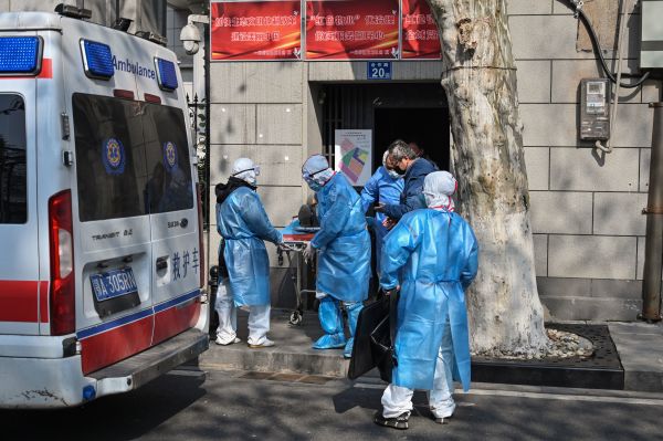 2020年1月30日，湖北省武漢市身著防護服的醫務人員從一間懷疑感染病毒的公寓中帶走一名患者。