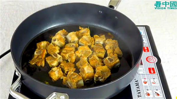 锅内放入姜片、葱段，炒香后放入排骨，浇入酱料、加水。