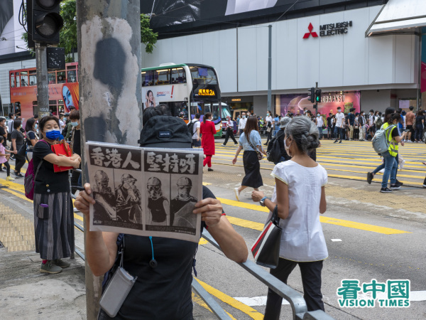 市民舉起「香港人 堅持呀」的紙牌。（圖片來源：龐大衛/看中國）