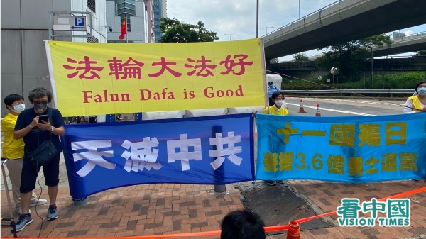 中共建政71週年，香港法輪功學員在中聯辦門前打出「法輪大法好」「天滅中共」等橫幅。