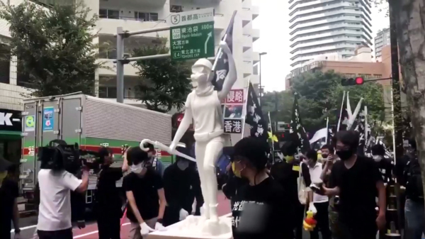 日本東京有港人和民眾推著民主女神像上街遊行聲援12港青。（圖片來源：12港人關注組直播截圖）
