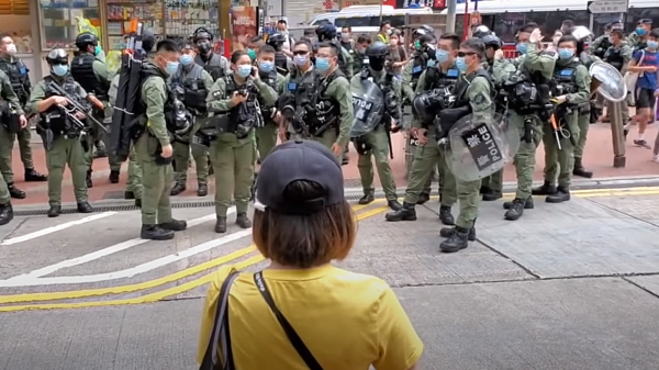10月1日，銅鑼灣有大量防暴警察戒備，一位黃衣少女出現，隻身向在場警員喊話。（圖片來源：看中國視頻截圖）