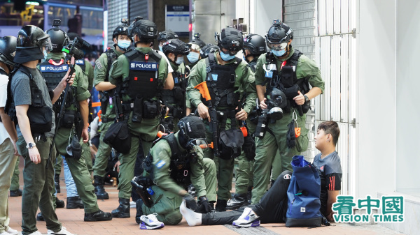 香港民間人權陣線原定發起的十一遊行在港警封殺下取消，但港人仍自發走上街頭，聲援遭大陸關押的12名抗爭者。警方為阻市民表達訴求無所不用其極，拘捕包括區議員在內的80多人。（圖片來源：李天正/看中國）