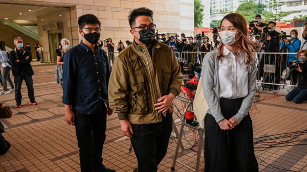 前香港众志秘书长黄之锋、前成员周庭及前主席林朗彦12月23日因反送中包围警总案被还柙，上庭前见记者。