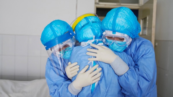 医务人员在山东省邹平市的一家医院隔离病房里互相拥抱。