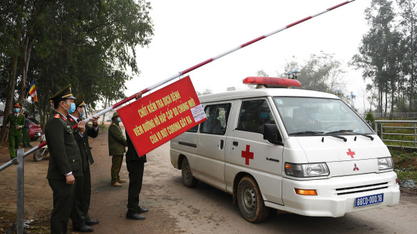 為防中共肺炎（COVID-19），越南警察戴著防護口罩，讓救護車在永福省Son Loi鎮的一個檢查站通過。