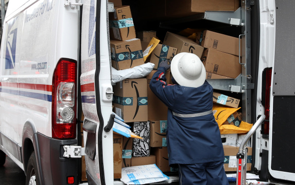 美國郵政服務USPS的一名工人在裝運包裹。