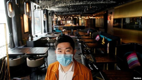 2月12日，上海市中心seul&SEUL飯店的老闆Bill Hu戴著口罩站在空無一人的店堂裡。