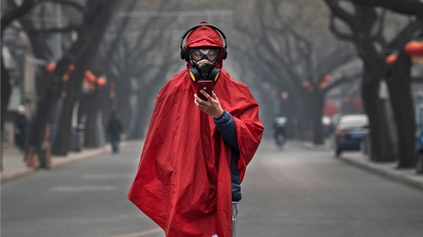 1月26日，一名中國男子戴著防護口罩、護目鏡，穿著外衣站在北京街道上