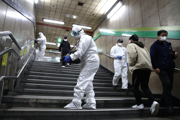 2020年2月21日，戴着防护装备的消毒人员在首尔地铁站喷洒消毒剂。