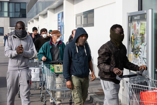2020年2月23日，義大利人戴著口罩等待進入商場購物。