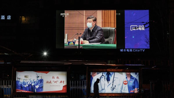 3月10日，街上一个大屏幕显示习近平戴口罩现身武汉