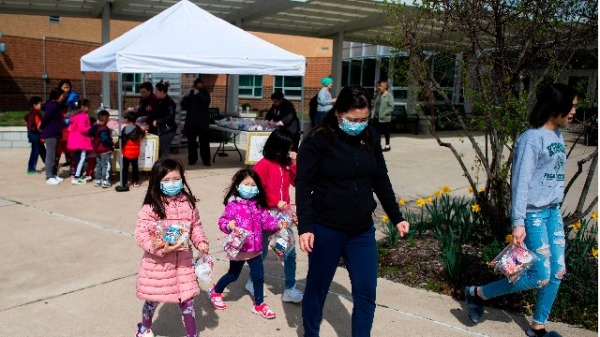 近日来，美国多州的武汉肺炎疫情再度回升，有些州暂停松绑措施。图为美国维州戴着口罩的家长和孩子。（图片来源：ANDREW CABALLERO-REYNOLDS/AFP/Getty Images）