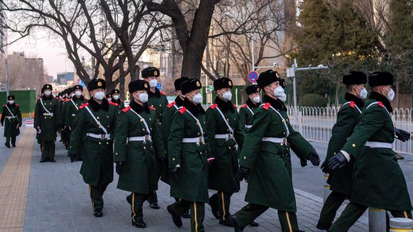 大疫衝擊政局，涉北京防務的軍方關鍵人物接連異動。圖為一隊軍警戴著口罩行走在北京街頭。