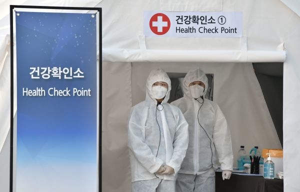 2020年3月18日，在韩国水原三星电子公司的股东大会上，医务人员在会议厅外的健康检查站等待。