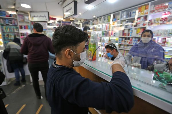 2020年2月24日，一個戴口罩的男子在伊朗首都德黑蘭的一家藥店購物。