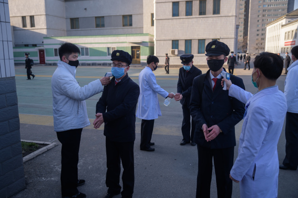 2020年4月22日，朝鲜平壤医科大学的学生在进校门前要进行消毒，并体温检查。