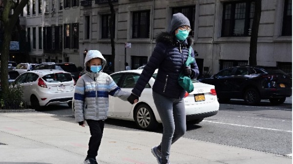 4月15日，戴着口罩的两母子走在纽约街头上