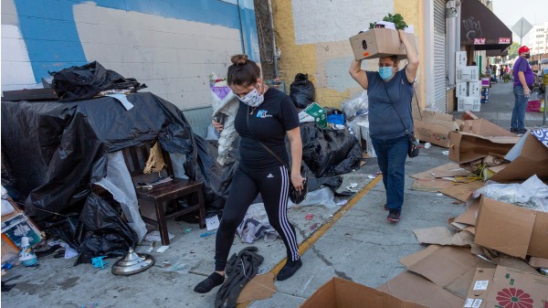 報告指出，今年夏天，全美將有近80萬名無家可歸的遊民。民眾走過加州洛杉磯髒亂不堪的遊民聚集區。（圖片來源：David McNew/Getty Images）