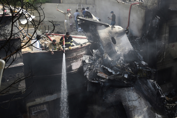 2020年5月22日，巴基斯坦国际航空公司的飞机在卡拉奇的一个居民区坠毁后，消防员在灭火。