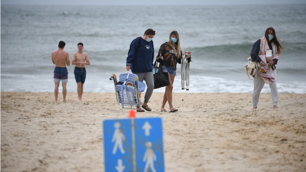2020年5月24日陣亡將士紀念日週末，紐約蒙托克的民眾戴口罩在公共海灘遊玩。（圖片來源：Astrid Riecken/Getty Images）