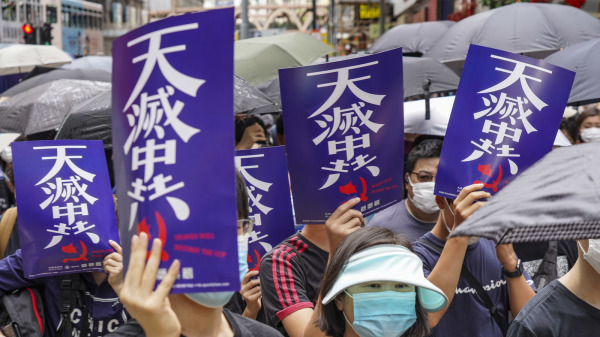 香港抗爭者在集會上舉起天滅中共的海報.