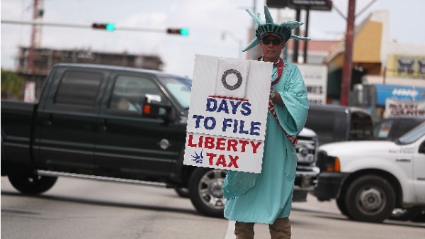 2019年4月15日 一名男子手持報稅的字牌站在佛州大街上