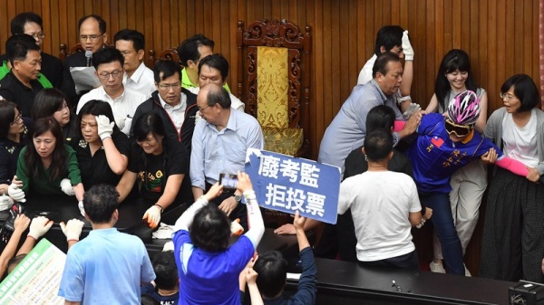 最後國民黨立委剩下陳玉珍（粉色安全帽者）一人在台上，直至4時36分，立法院長游錫堃（後左2）進場宣布開會，陳玉珍才被拖出場外。
