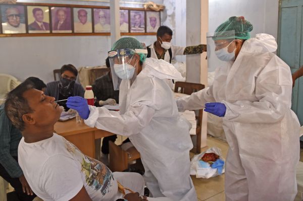 2020年7月22日，印度医务人员在采集病毒检测样本。
