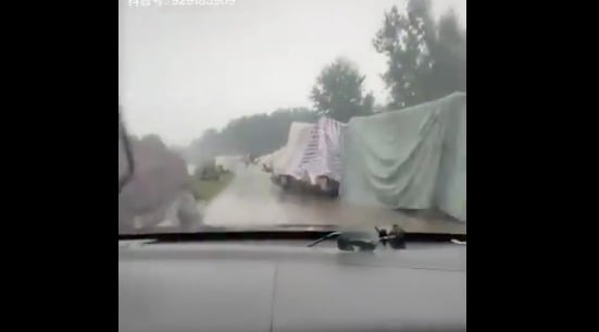 安徽某河堤排滿了災民們自己用塑料布、編織材料搭建的簡易帳篷