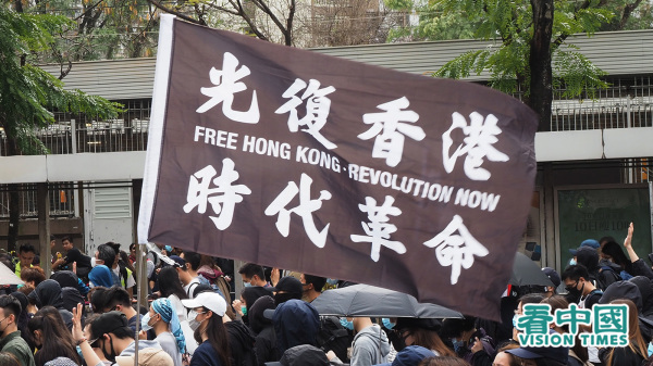 反送中示威中，港人高举“光复香港 时代革命”旗帜。