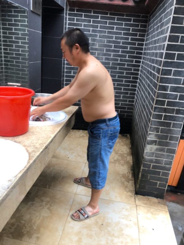 炎夏裡又被停水停電，陳雲飛不得不在公廁洗衣。