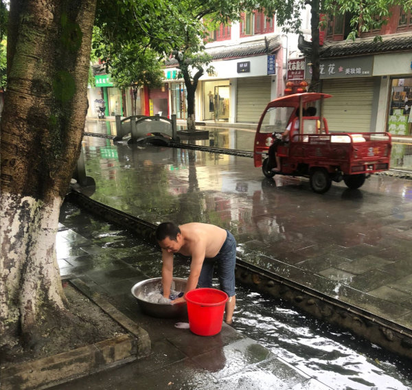 房子被停水停電，陳雲飛要用街上溝裡的水洗衣服。此圖片來自推特，拍攝日期不詳。