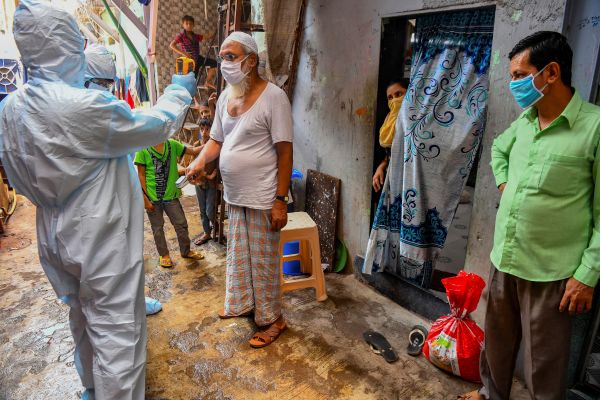 2020年6月24日，身穿个人防护设备的医务人员在孟买达拉维贫民窟做医疗检查。