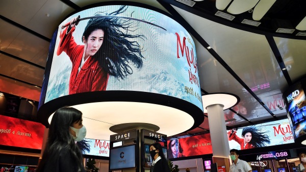 2020年9月8日，人们在曼谷一家购物中心的电影院里走过迪士尼花木兰电影的广告显示