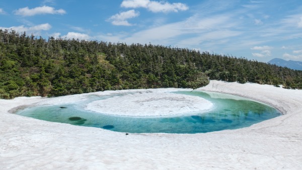 日本八幡平山頂的鏡沼，春雪融化時罕見的「龍之眼」自然奇景。（圖片來源：Adobe Stock）。