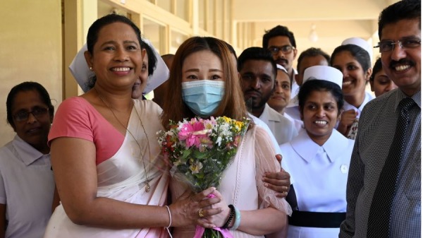 一名中国游客（C）经武汉肺炎的病毒检测呈阳性反应并接受被隔离治疗，她出院后与斯里兰卡卫生部长Pavithra Wanniarachchi（前L）和医护人员合影
