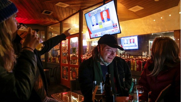 2020年11月3日晚，美國人在西雅圖一家酒吧觀看大選夜實況。（圖片來源：JASON REDMOND/AFP via Getty Images）
