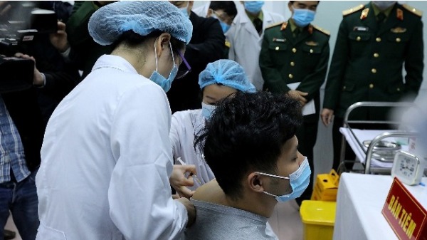 越南军方医疗人员在向志愿者注射越南制药公司Nanogen开发的Covid-19疫苗