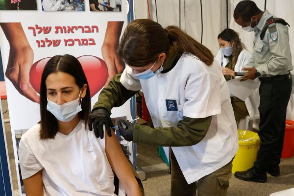 2020年12月28日，一名以色列军医在以色列小镇里雄莱锡安的军事基地的医疗中心接受了COVID-19疫苗接种。