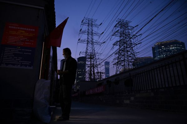 2021年9月28日，在北京，一名男子站在電線下面的門口。