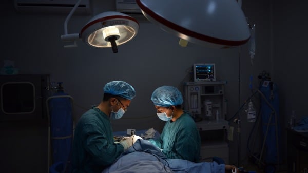 2013年8月9日整形外科医生王旭明（L）在重庆诊所为患者进行“特殊”的鼻子手术。