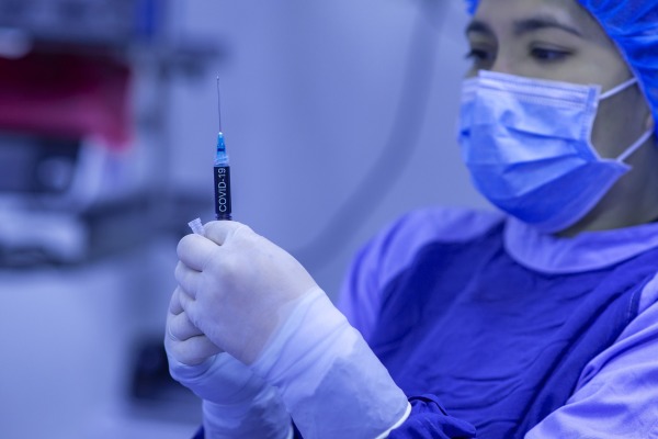 图为一名洛杉矶的护士在准备新冠病毒疫苗注射。