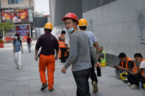 2021年8月30日，一名工人走過北京的一個建築工地時回頭看。