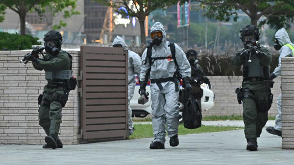 11月19日，香港跨部門反恐專責組在西九龍高鐵進行反恐演習。圖為警方爆炸品處理課人員在反恐特勤隊的保護下，處理懷疑化生輻核裝置。（圖片來源：香港政府新聞處）